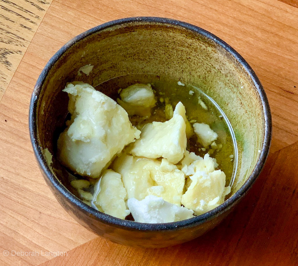 Chunks of Shea butter in a bowl with Organic Avocado Oil