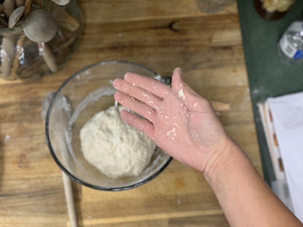 Hand showing sourdough dough sticking to it