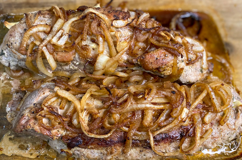 two roasted pork tenderloins topped with cartelized onions