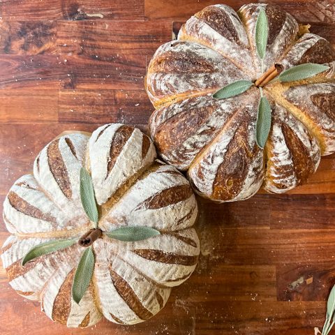 Pumpkin Pie Sourdough Bread: A Cozy Fall Loaf two loaves of pumpkin shaped pumpkin pie sourdough bread on a cutting board