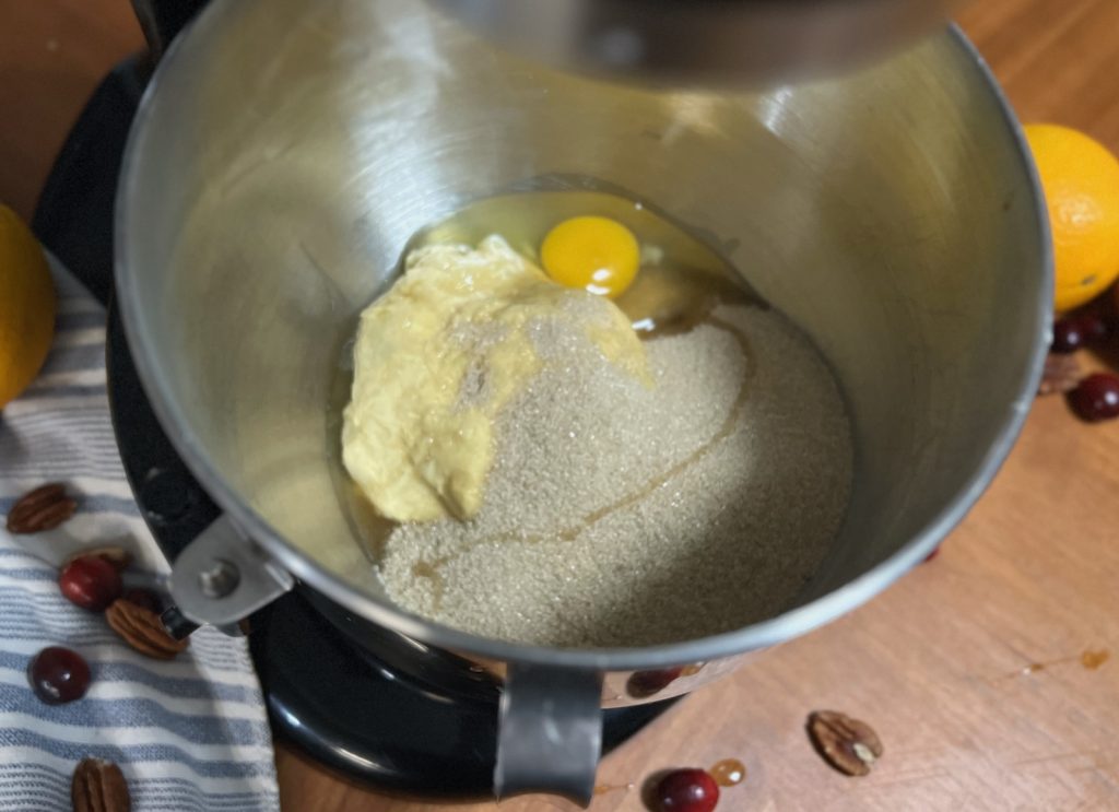 Butter, sugar and egg in a stand mixer bowl for cranberry orange sourdough bread.