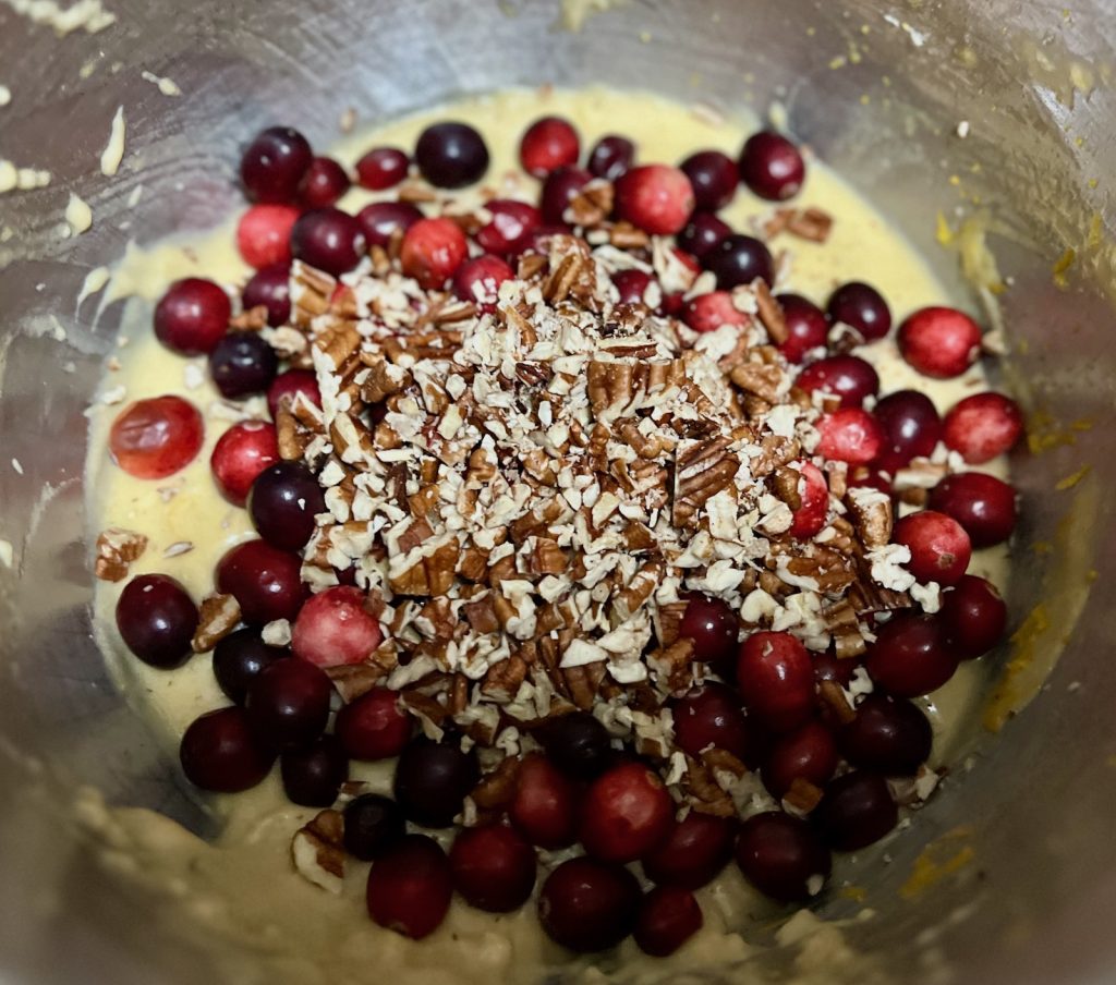 Fresh Cranberries and chopped pecans added to cranberry orange sourdough bread batter.