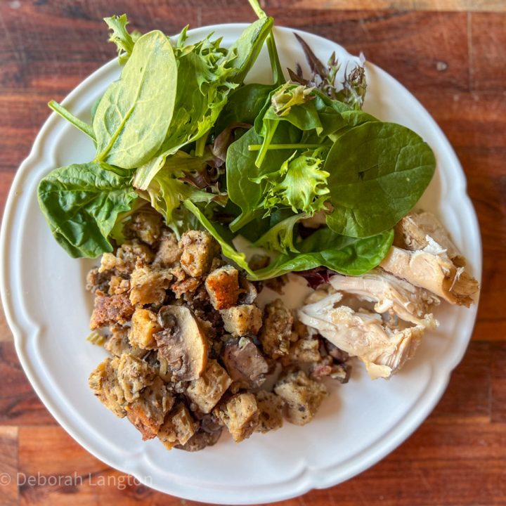 Sourdough Stuffing on a dinner plate with roasted chicken and fresh salad greens