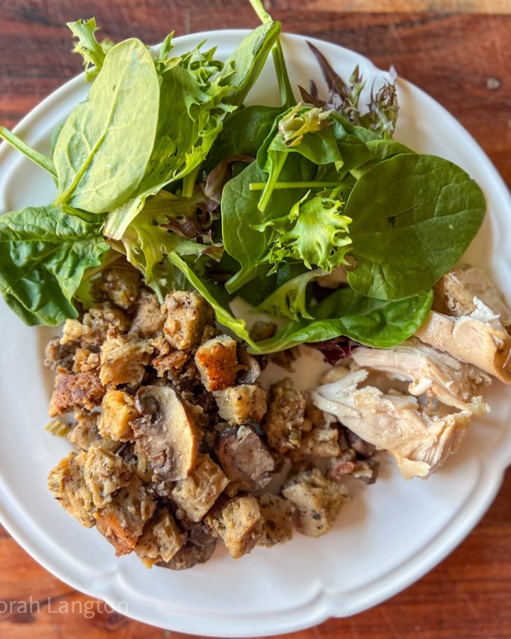 Sourdough Stuffing on a dinner plate with roasted chicken and fresh salad greens