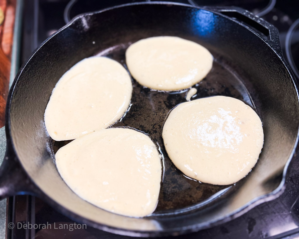 4 pancakes freshly poured into pan