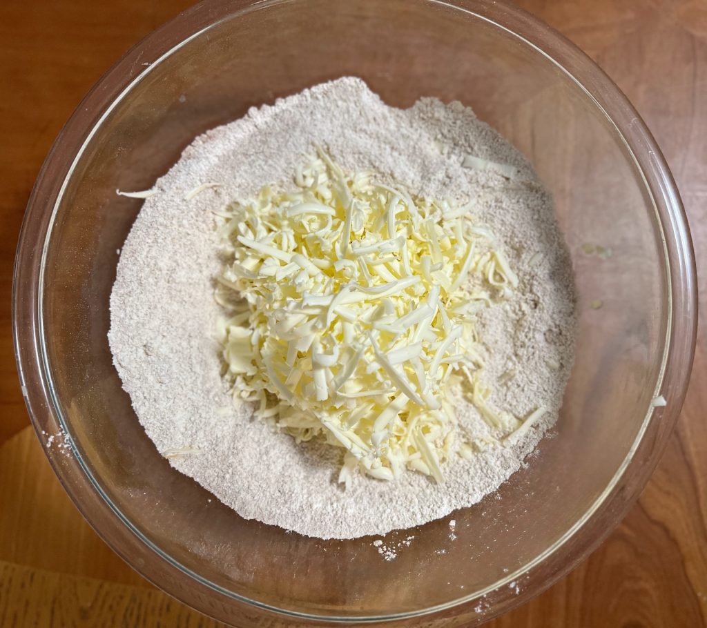 Cold grated butter added to fresh-milled flour for pumpkin sourdough scones.