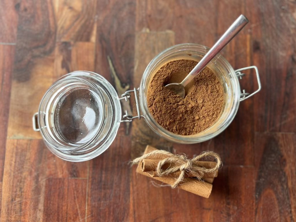 Homemade pumpkin pie spice scooped from a glass storage jar