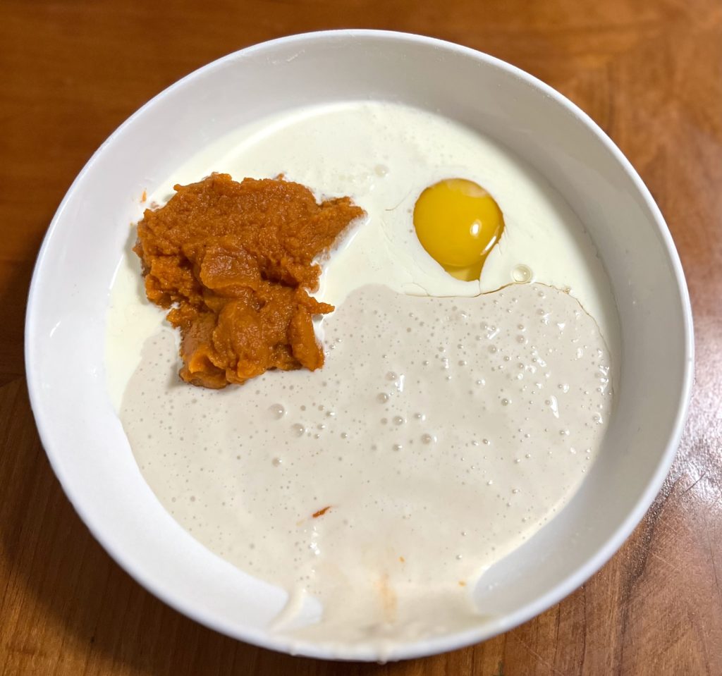 Pumpkin puree, sourdough discard, egg, cream, and vanilla ready to be mixed for scones.