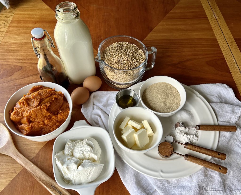 Ingredients for fresh-milled pumpkin muffins arranged on a wooden table