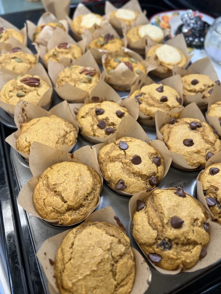 Assortment of fresh-milled pumpkin muffins with chocolate chips, pecans, cream cheese topping, and plain.
