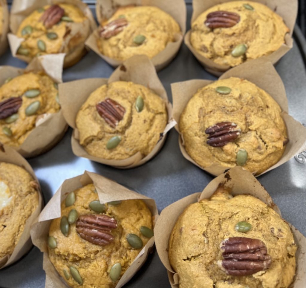 Fresh-milled pumpkin pecan muffins topped with pecan halves and pumpkin seeds