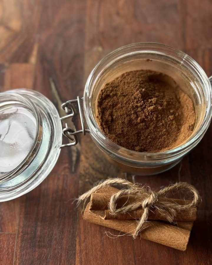 Homemade pumpkin pie spice in a glass latch jar with cinnamon sticks