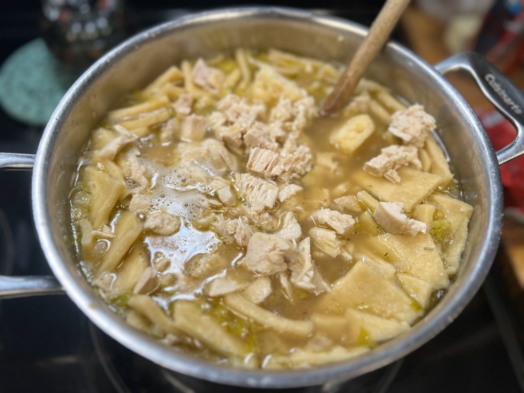 Pot of Southern chicken and homemade rolled sourdough discard dumplings
