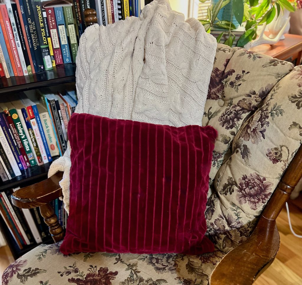 Cable Knit blanket draped over rocking chair to make your home feel cozy for fall