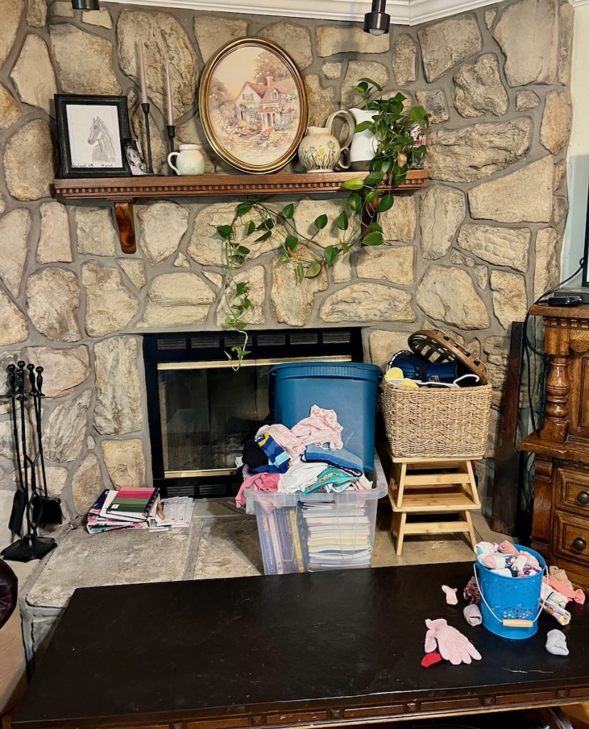 Cluttered fireplace before making breathing room and decluttering.