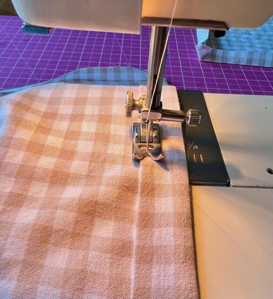 Sewing a straight seam along the folded hem of a curtain panel