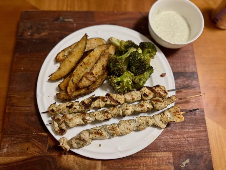 Grilled chicken skewers with roasted potato wedges, broccoli, and ranch dip